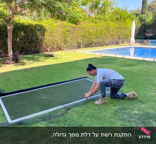 אדם עובד על מסגרת אלומיניום בגינה ליד בריכה